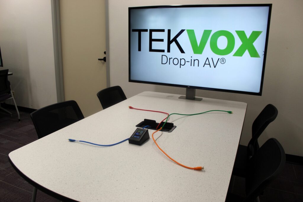 Table with large screen showing TekVox logo