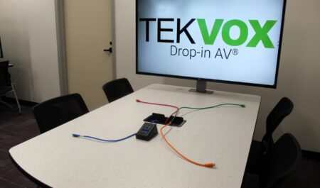 Table with large screen showing TekVox logo